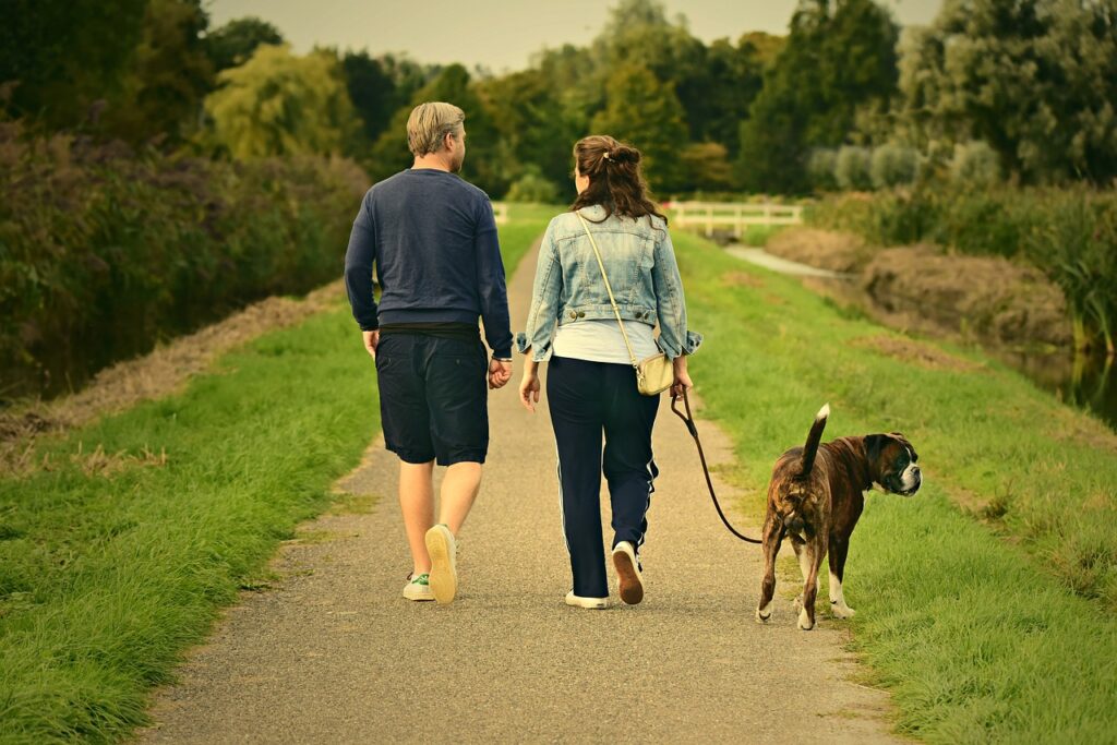 Paar Spaziergang Hund Rückenschmerzen beim Gassi gehen Was kann helfen